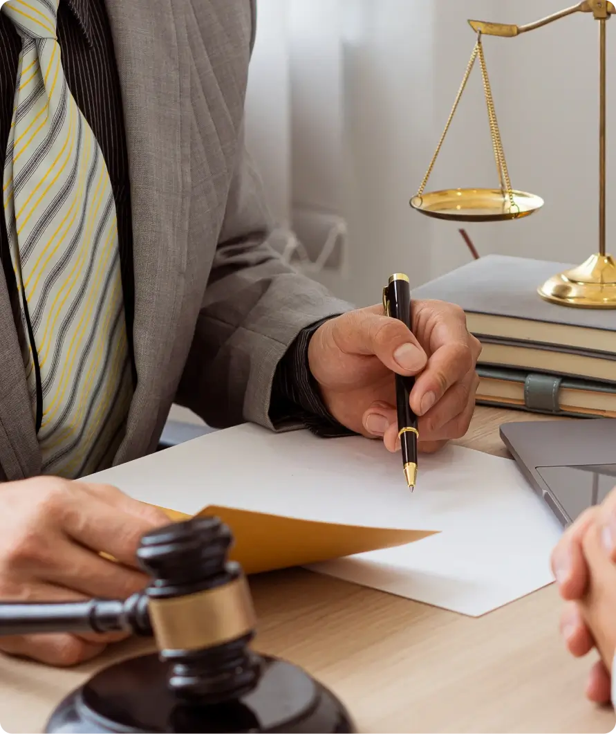 Lawyer signing legal document with gavel.