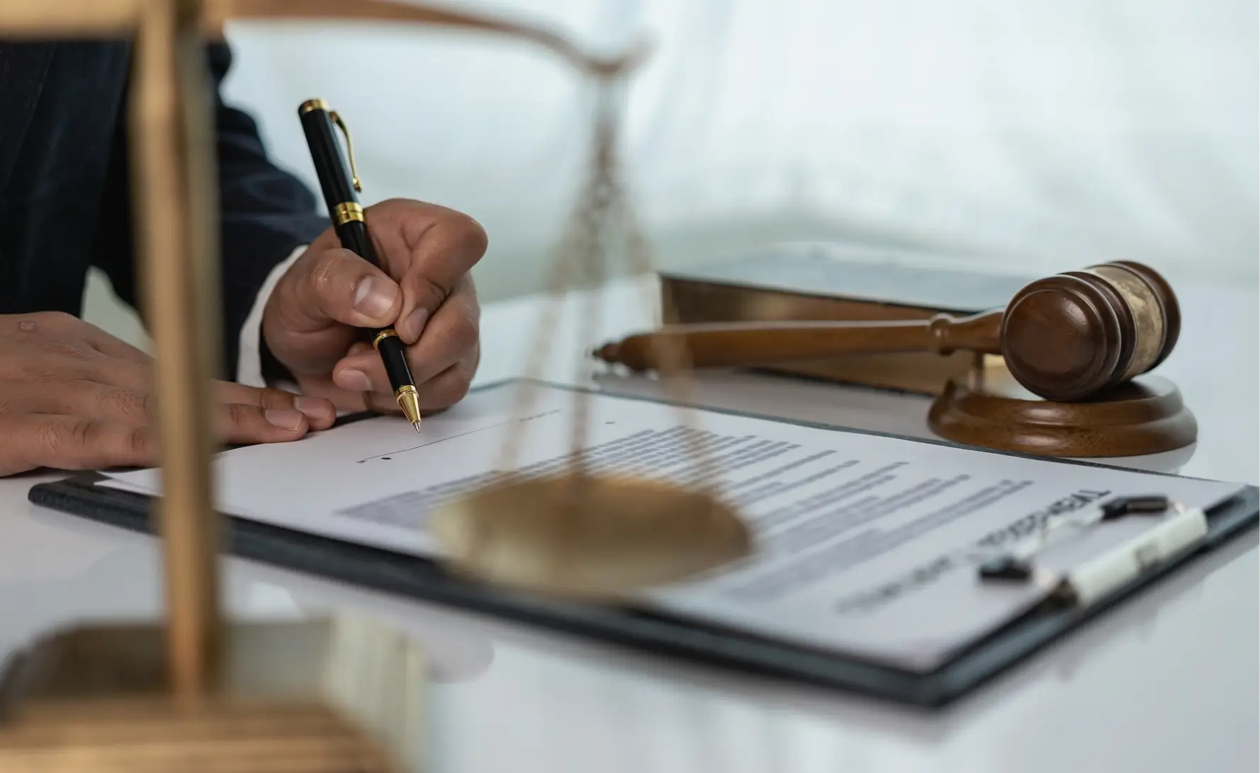 Here's an alt tag for the image: Lawyer signing legal document.