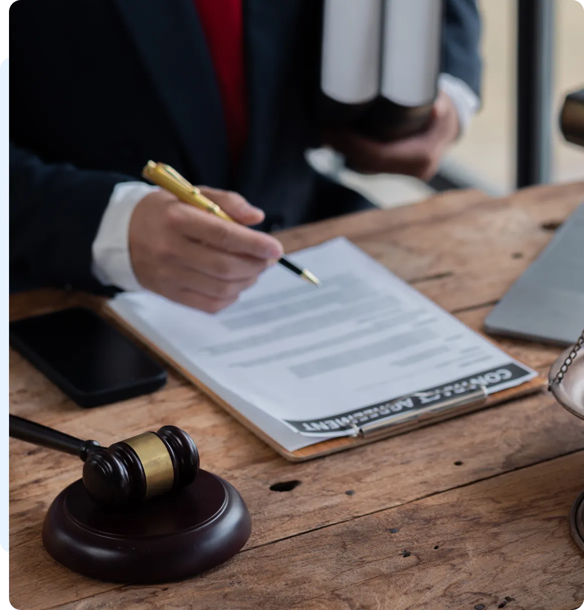 Lawyer reviewing contract, gavel on desk.